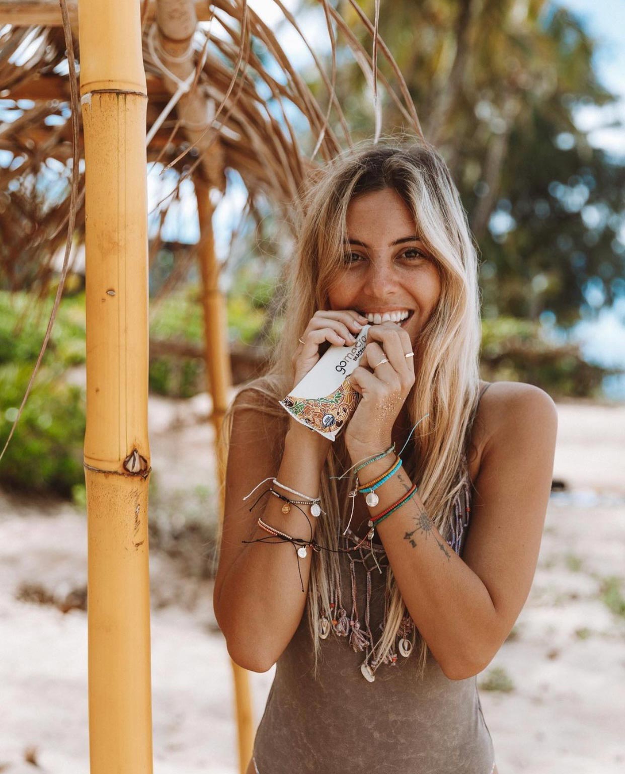 Young Healthy Woman Enjoying a GoMacro Bar on the Beach
