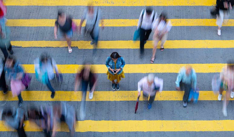 Crowd walking across a yellow crosswalk