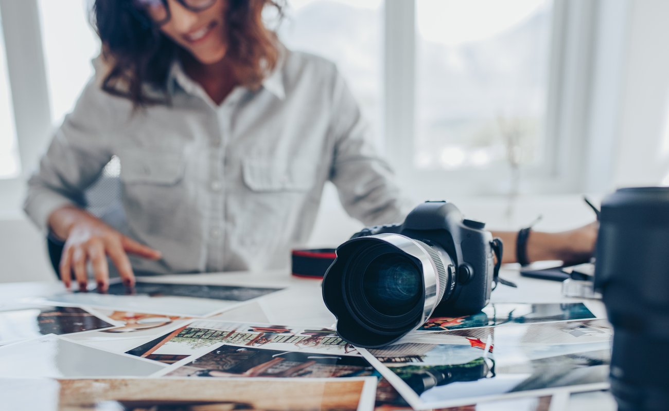 Woman looking at pictures on a table with a camera