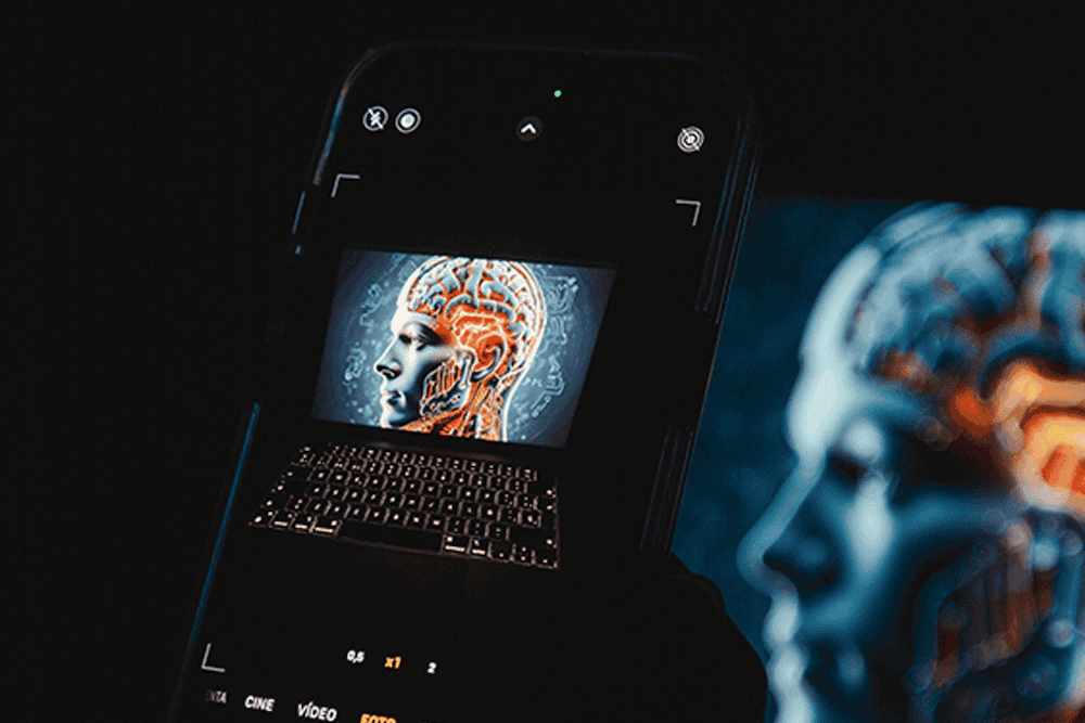 Smartphone camera capturing a glowing AI brain circuit illustration on a laptop