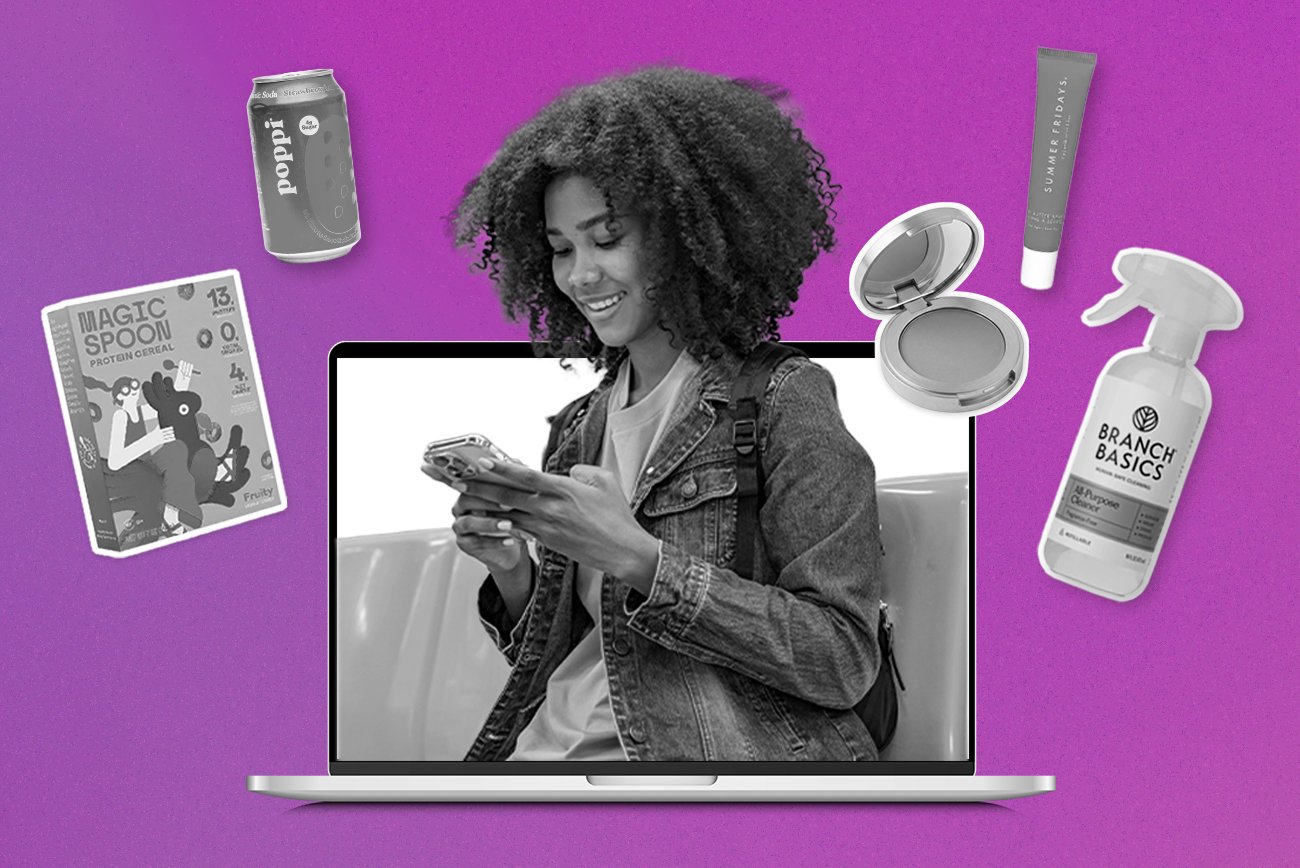 Consumer on her phone on a laptop screen surrounded by culture-driven brands