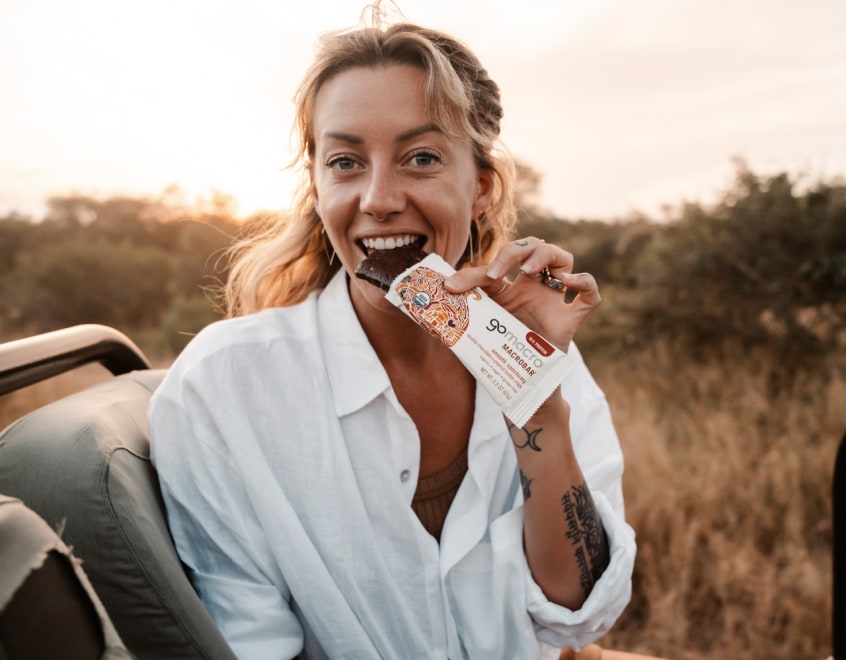 Woman eating a GoMacro protein bar