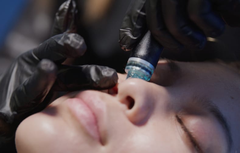 Person using a Hydrafacial device on a client